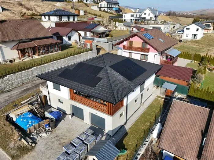 Pohľad z dronu na rodinný dom s fotovoltickými panelmi na dvoch stranách strechy